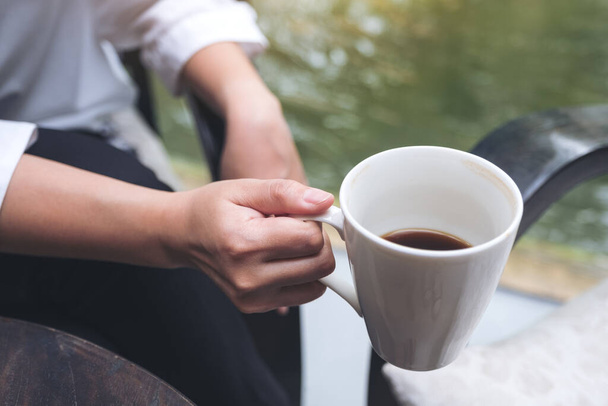 Imagen de cerca de una mujer sosteniendo una taza de café antes de beber por la mañana
 - Foto, imagen