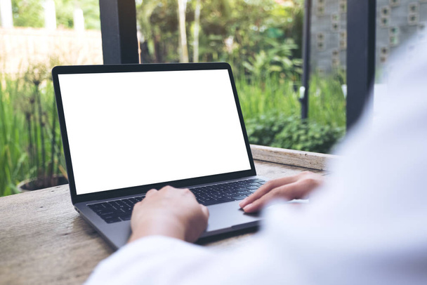 Mockup immagine di una donna che utilizza e digita sul computer portatile con schermo bianco vuoto desktop con sfondo naturale
 - Foto, immagini