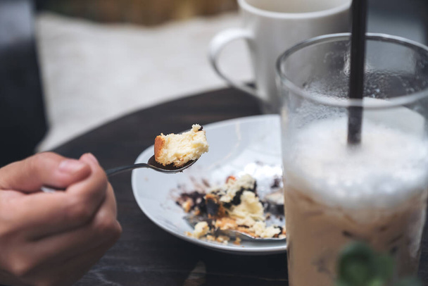 Imagen de cerca de una mujer disfrutar de comer pastel de queso y café en la cafetería
 - Foto, imagen