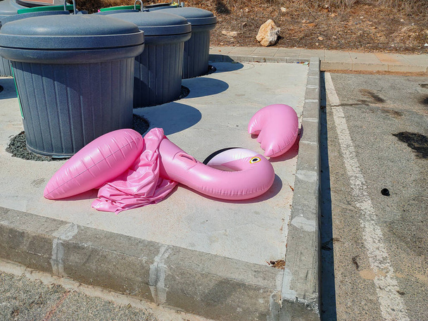 Giocattolo della piscina deflazionato pulito bidone della spazzatura al resort. Concetto di fine vacanza o inquinamento ambientale
. - Foto, immagini