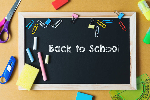 School supplies on black board background. Back to school concept - 写真・画像