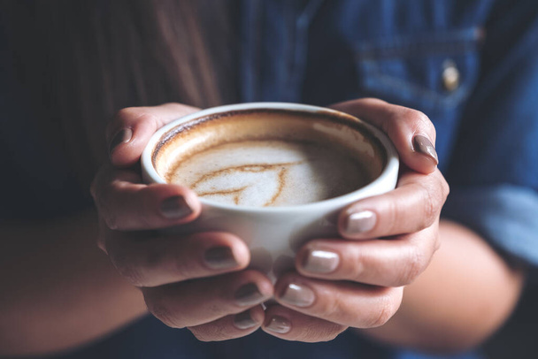 Imagen de cerca de una mujer sosteniendo una taza de café antes de beber con sentirse bien y relajado en la cafetería
 - Foto, Imagen