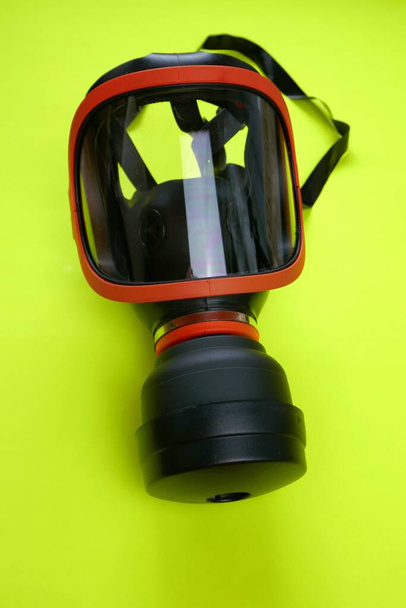 Máscara protectora con filtro. máscara de seguridad con un respirador sobre fondo de neón amarillo brillante
 - Foto, imagen