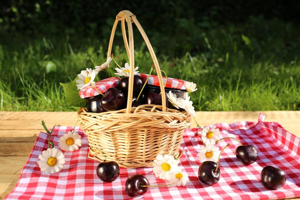 mermelada de cereza en una cesta al aire libre picnic  - Foto, imagen