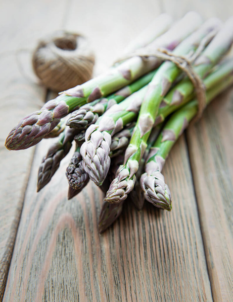 Bundle of fresh green asparagus on a rustic wooden table , top view - Foto, immagini