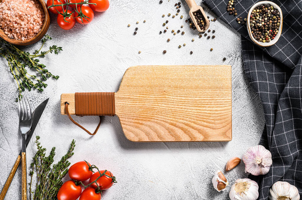 Wooden cutting board in center of Fresh raw greens, vegetables. Healthy, clean eating, vegan, dieting food concept. White background. Top view. Copy space. - Zdjęcie, obraz