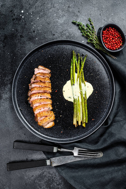 Grilled Duck fillet steaks with asparagus. Black background. Top view. - 写真・画像