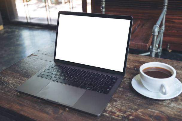 Макет ноутбука з порожнім білим настільним екраном і чашкою кави на дерев'яному столі в сучасному кафе
 - Фото, зображення