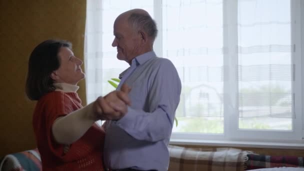 happy family, elderly lively couple middle aged woman and man relaxing together having fun dancing at home celebrate anniversary enjoy caring and tenderness - Footage, Video