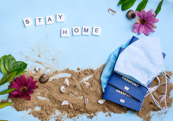 Spiaggia di sabbia su uno sfondo blu con lettere di legno e una parola di soggiorno. Vacanze a casa
 - Foto, immagini