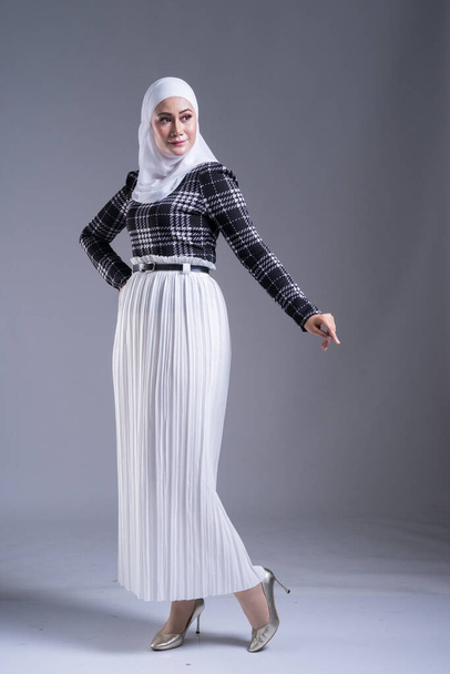 Ritratto integrale di una bella modella musulmana in hijab e abbigliamento casual su sfondo grigio. Hijab e stile di vita musulmano concetto di moda
 - Foto, immagini