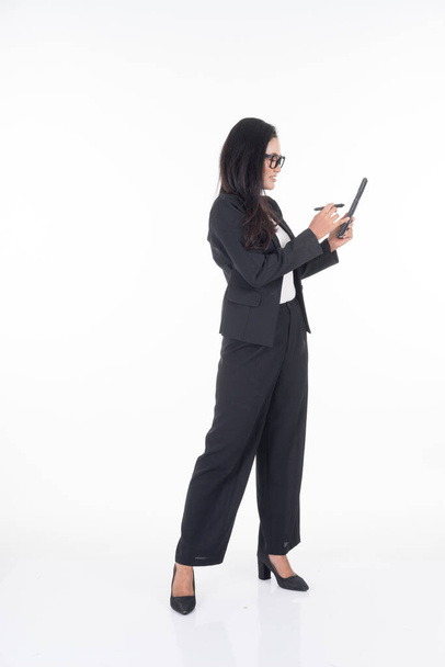Eine attraktive Frau in Businesskleidung hält ein Tablet mit verschiedenen Posen auf weißem Hintergrund. Geeignet für Bildausschnitte und Manipulationsarbeiten für Technologie-, Wirtschafts- oder Finanzthemen - Foto, Bild