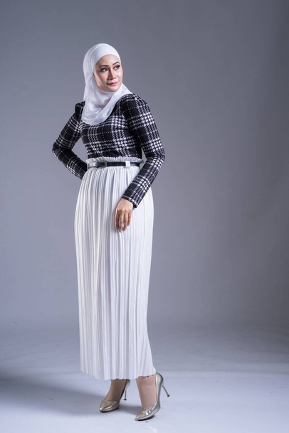 Ganztägiges Porträt eines schönen muslimischen Models in Hijab und Freizeitkleidung auf grauem Hintergrund. Hijab und muslimisches Modekonzept - Foto, Bild