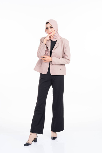 Full length portrait of a beautiful Muslim female model in a hijab and officewear isolated on grey background. Hijab and Muslim fashion lifestyle concept - Фото, зображення