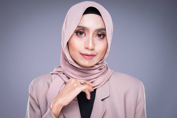 Заголовок красивої мусульманської жінки-моделі в хіджабі і службове вбрання ізольоване на сірому тлі. Хіджаб і мусульманський стиль життя - Фото, зображення