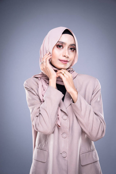 Retrato de media longitud de una hermosa modelo musulmana en un hijab y ropa de oficina aislada sobre fondo gris. Hijab y el concepto de estilo de vida musulmán
 - Foto, Imagen