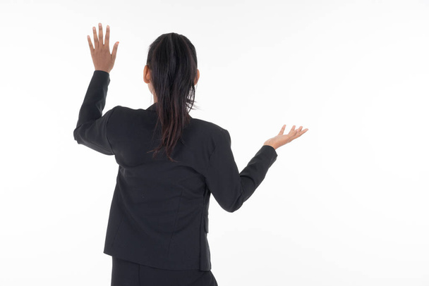Atrakcyjna kobieta w stroju biznesowym machająca rękami w powietrzu, poruszająca się na niewidzialnym ekranie odizolowanym na białym. Nadaje się do wycinania obrazów i manipulacji prac dla technologii, biznesu. - Zdjęcie, obraz