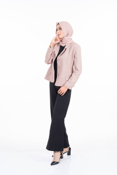 Full length portrait of a beautiful Muslim female model in a hijab and officewear isolated on grey background. Hijab and Muslim fashion lifestyle concept - Photo, Image