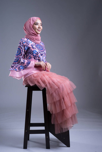 Повний портрет красивої жінки, одягненої в традиційне вбрання і хіджаб, стиль життя для мусульманок на сірому тлі. Idul Fitri and hijab fashion concept. - Фото, зображення