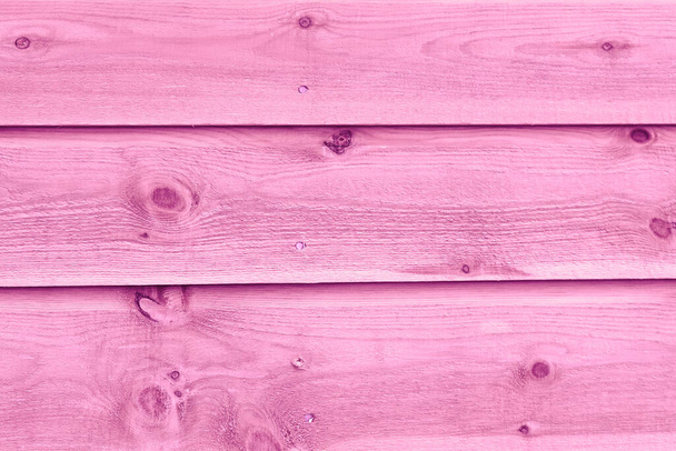 Texture of a fragment of a wooden house wall. The wall is painted pink color. - Foto, imagen