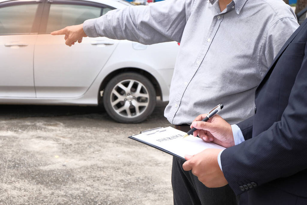 Agente de seguros de ajustador de pérdidas que inspecciona el enfoque selectivo del automóvil dañado
 - Foto, imagen