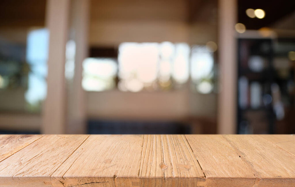 Prázdný dřevěný stůl před abstraktním rozmazaným pozadím kavárny. může být použit pro zobrazení nebo vyladění vašich výrobků.Vyhonit pro zobrazení výrobku - Fotografie, Obrázek
