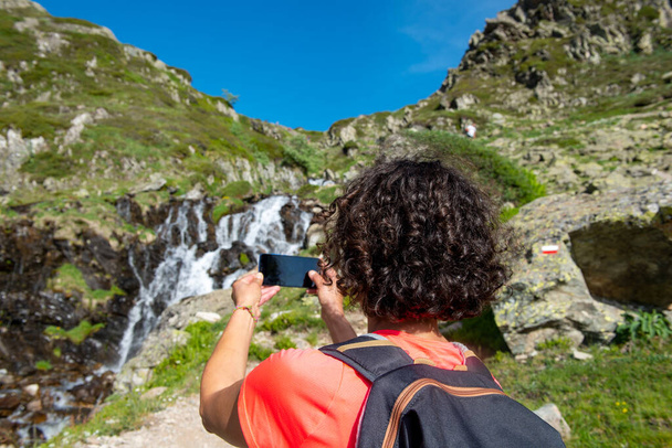 una excursionista cerca de la cascada salvaje salpicadura
 - Foto, Imagen