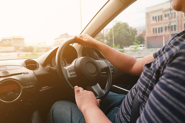Ο άνθρωπος που οδηγεί με τα δύο χέρια στο τιμόνι επιλεκτική εστίαση. έννοια της οδήγησης ασφάλειας - Φωτογραφία, εικόνα