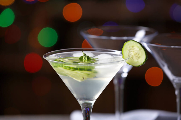 Bicchiere di gustoso martini al cetriolo su sfondo scuro
 - Foto, immagini