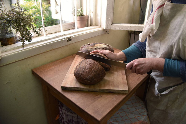 Cortar pão em fatias. Pão caseiro
 - Foto, Imagem