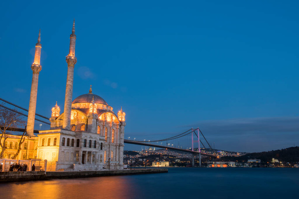 Ortaköy Camii ve Boğaziçi Köprüsü (15 Temmuz Şehitler Köprüsü) gece manzarası. İstanbul, Türkiye. - Fotoğraf, Görsel