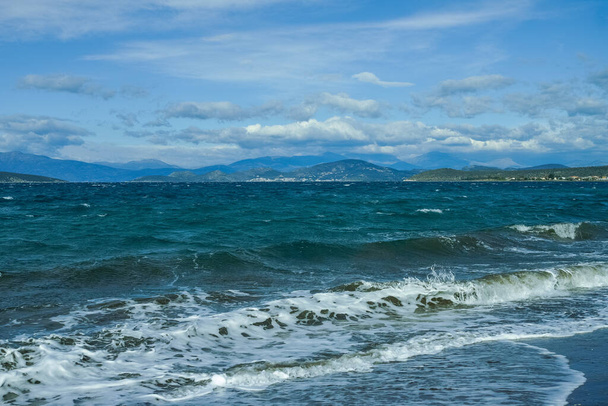 Dramático paisaje marino colorido con olas de agua y vista de las montañas del Peloponeso, Grecia
 - Foto, imagen