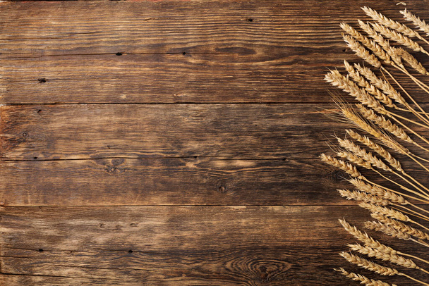 Old wooden table with spikelets wheat bakery. copy space - 写真・画像