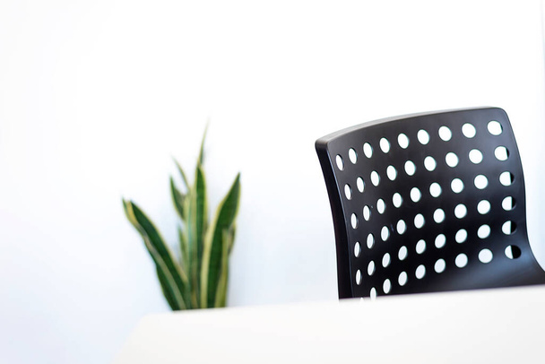 Thuis werkplek met witte bureaublad en zwarte stoel - Foto, afbeelding