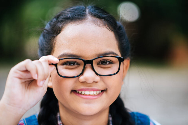 Beauty portrait of a young girl holding glasses and looking at camera  - Photo, image