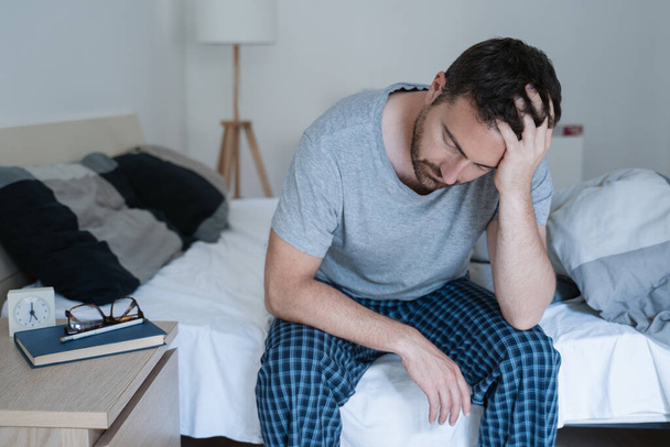 Homem inquieto acordando cedo com dor de cabeça após a noite áspera
 - Foto, Imagem