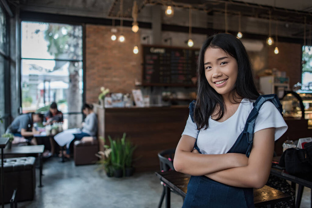 A kávézó kávézójában mosolygó fiatal nő portréja - Fotó, kép