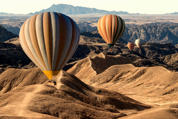 Colorful hot air balloons flying over the moon valley mountain. Africa. Namibia. - Фото, зображення