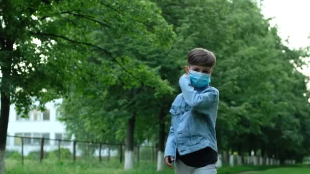 Küçük çocuk dışarıda tıbbi maskesini çıkarıyor. Çocuk karantinaya, koronavirüse, covid19 'a, kendini izolasyona son vermekten mutlu.. - Video, Çekim
