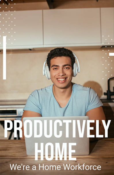 smiling bi-racial man listening music in headphones and using laptop near productively home, were a home workforce lettering  - Fotografie, Obrázek