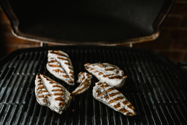 petto di pollo alla griglia su un barbecue piastra calda con il coperchio aperto
 - Foto, immagini