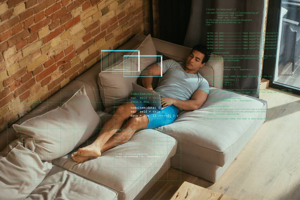 mixed race freelancer using laptop and chilling on sofa near virtual data illustration  - Foto, Imagen