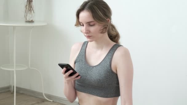 young fit pretty girl wearing sportswear sits in lotus pose meditating at home - Footage, Video