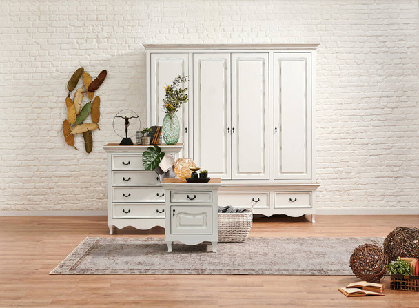 Weiße klassische Schublade und Kleiderschrank im Schlafzimmer und weiße Backsteinwand Hintergrund. - Foto, Bild