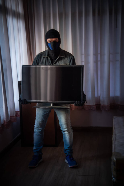 Грабитель в черной маске крадет квартиру
 - Фото, изображение