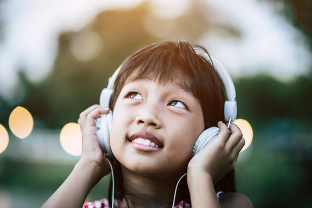 Bambina che ascolta musica nel parco
 - Foto, immagini