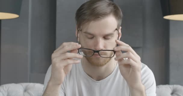 Slow-mo, tired man taking off eyeglasses and rubbing temples. Slow motion of exhausted young Caucasian brunette guy having headache and stress. Migraine, overworking. Cinema 4k ProRes HQ. - Séquence, vidéo