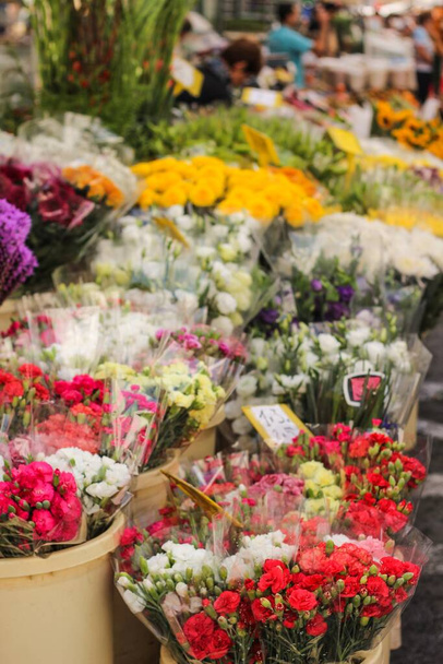 A vertical selective focus shot of colourful flower bouquets in an outdoor shop - Fotó, kép
