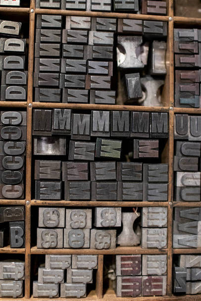 caracteres móveis tipográficos coletados em uma gaveta para tipografia. coleção de peças de arte antiga tipografia com caracteres móveis. elementos de uma tipografia para imprimir letras
 - Foto, Imagem