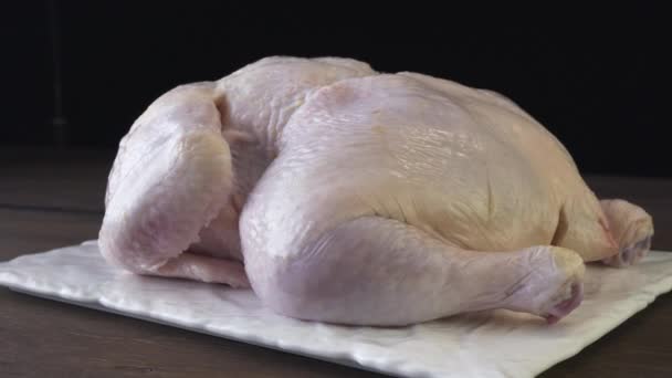 Peeled broiler chicken on a black background - Footage, Video